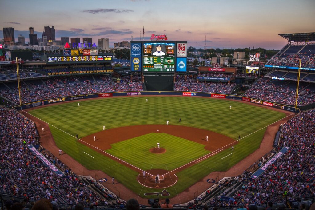 Photo: a long shot of a baseball field from seats high above home plate; crowds in stands along left and right sides and across the field behind the fences,
