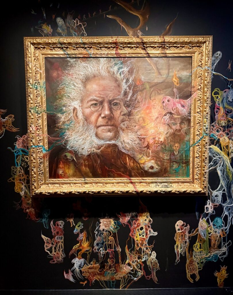 Portrait of Ibsen as an old man, surrounded by multi-colored, dream-like figures painted on the frame and the wall.