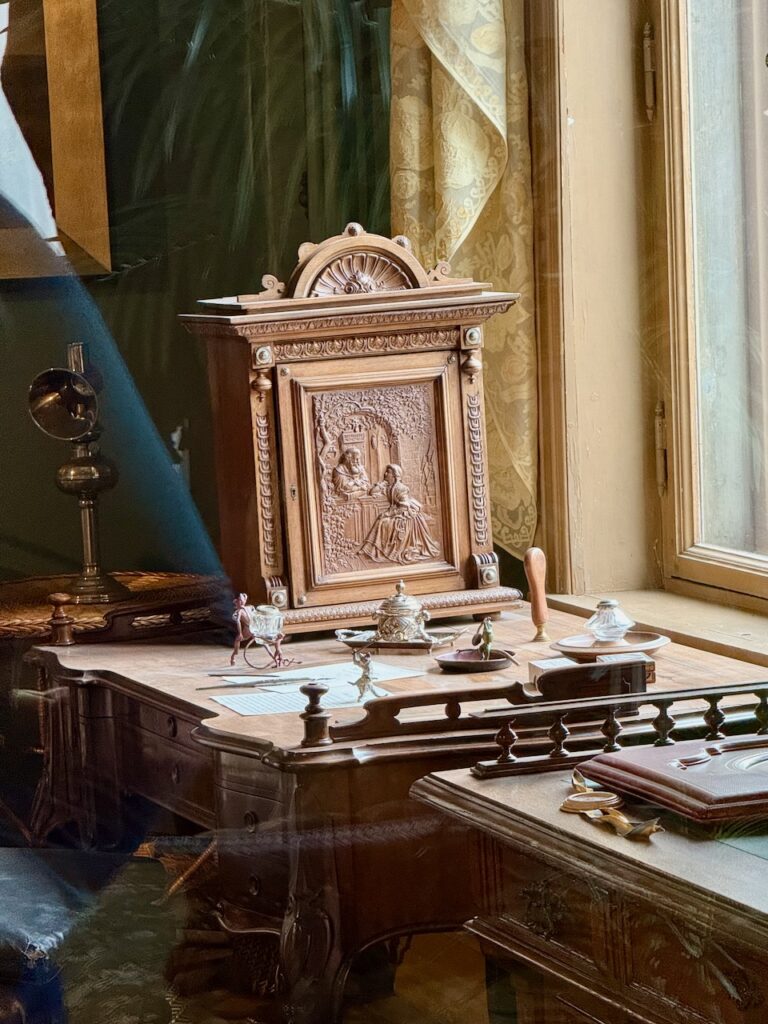 Close-up of items on desk in Ibsen's study: intricately carved wooden box and several figurines.